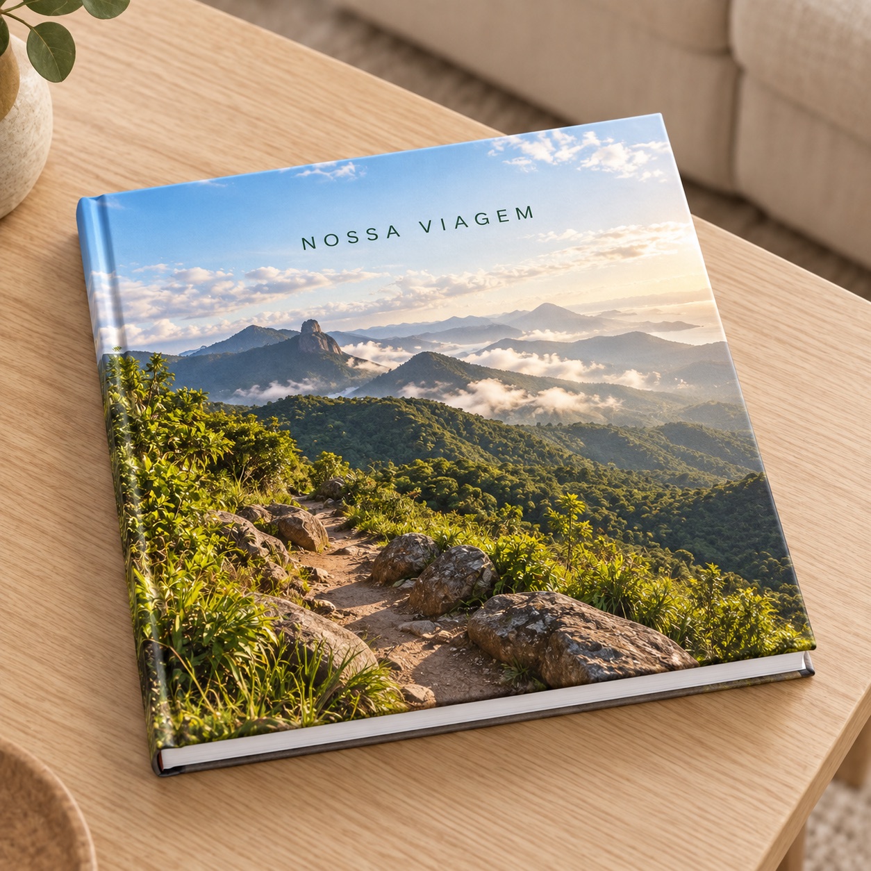 Inspiração ilustrativa de fotolivro com montanhas na capa sobre uma mesa.